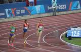 Se observa a tres deportistas corriendo en la pista
