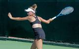 Se muestra a una tenista jugando con la raquete al aire
