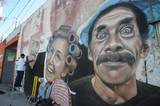 Se observa al artista urbano pintando el mural y está la cara de Don Ramón y Doña Florinda