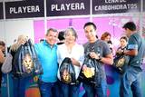 Se observan tres personas mostrando su mochila oficial del Maratón León 2023