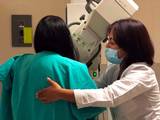 Se observa a una doctora revisando pechos mamarios