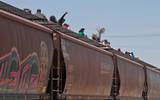 Se observa un vagón de tren con migrantes arriba