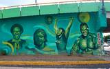 Se observa el mural con colores verdes del Charro Lomelí